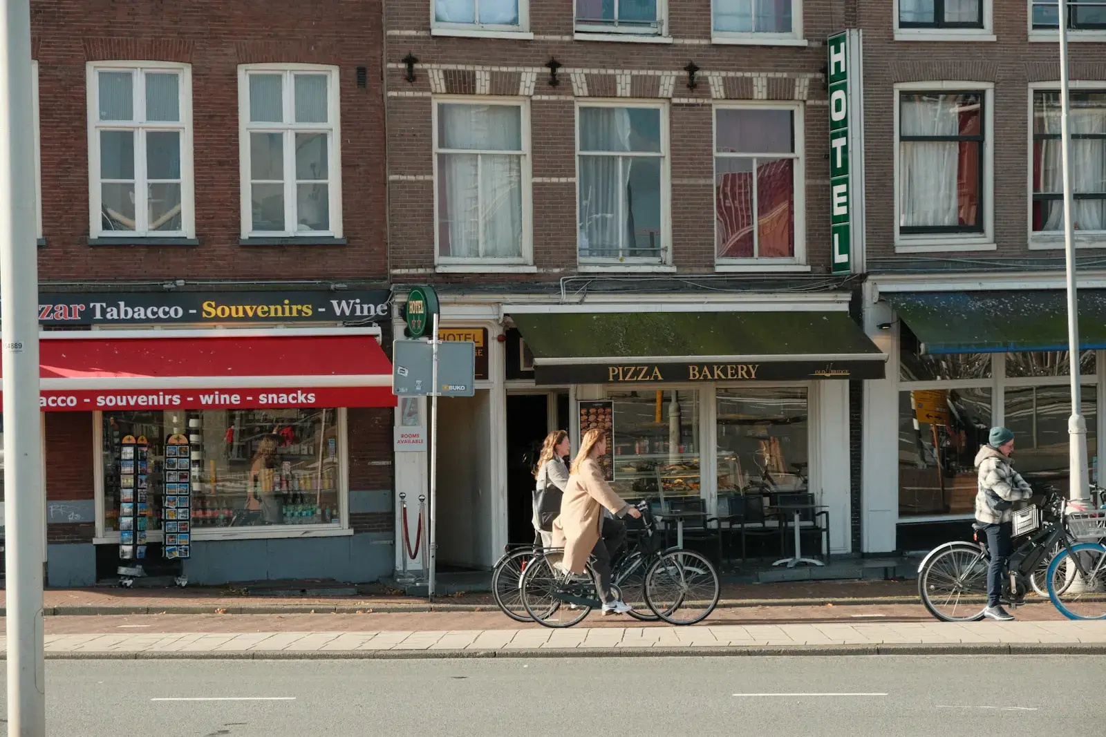 Een fietser rijdt langs de winkels van een Amsterdamse straat